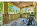 Cozy front porch with stone columns, wood railings, ceiling fan, and comfortable seating with a rocking chair at 1714 Parkhill Dr, Decatur, GA 30032