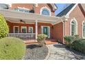 Inviting brick front porch with rocking chairs and a well-manicured landscape at 1414 Lynchburg Trce, Grayson, GA 30017