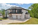 Side view of new construction two-story home featuring a two-car garage and modern design at 155 Westbrook St, Buford, GA 30518