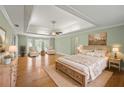 Spacious main bedroom with tray ceilings, hardwood floors, and a sitting area at 1135 Azalea Cir, Conyers, GA 30013