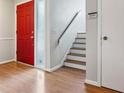 Bright entryway featuring hardwood floors, a vibrant red door, and staircase to the second level at 2005 Variations Ne Dr, Atlanta, GA 30329