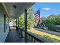 View from the covered porch, showcasing an American flag and serene neighborhood at 260 Sterling Dr, Powder Springs, GA 30127