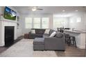 Open-concept living room with a fireplace, built-in shelves, and seamless flow to the kitchen at 3080 W Jackson Way, Austell, GA 30106