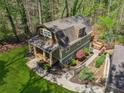 A beautiful gambrel roof home with lush landscaping, a covered carport, and a wraparound walkway at 3125 Lakeside Dr, Cumming, GA 30041
