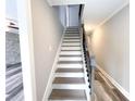 Elegant staircase with hardwood treads, white risers, and a decorative metal handrail at 1206 Park Place Dr, Jonesboro, GA 30236