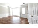 A bright living room featuring hardwood floors, modern wainscotting, and a stylish chandelier at 11050 Skyway Dr, Duluth, GA 30097
