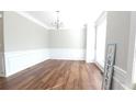 A bright living room featuring hardwood floors, modern wainscotting, and a stylish chandelier at 11050 Skyway Dr, Duluth, GA 30097