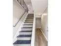 Modern staircase with gray and blue steps, white risers, and metal railing at 2457 Shiloh Dr, Decatur, GA 30034