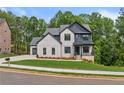 Charming two-story home with brick and siding, a manicured lawn, and mature trees at 6132 Hutchins Dr, Buford, GA 30518