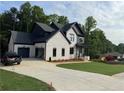 Charming two-story home featuring a brick facade, black accents, and well-manicured lawn at 6132 Hutchins Dr, Buford, GA 30518