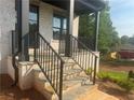 Inviting stone porch with black railings and pillars offering a warm welcome at 6132 Hutchins Dr, Buford, GA 30518