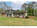 View of the front exterior showing the front yard and covered porch with white pillars at 1337 Frontier Trl, Sugar Hill, GA 30518