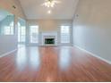 Spacious living room with vaulted ceiling, fireplace, wood floors, and plenty of natural light at 334 Royal Crescent Way, Stockbridge, GA 30281