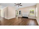 Spacious living room featuring hardwood floors, large windows, a ceiling fan, and a fireplace at 45 Chapman Way, Covington, GA 30016