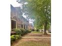 A quiet street view shows neatly kept townhomes with beautiful greenery and sidewalks at 6158 Thorncrest Dr, Tucker, GA 30084