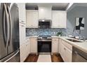 Modern kitchen featuring white cabinets, stainless steel appliances, and stylish backsplash at 2277 Peachtree Ne Rd # 507, Atlanta, GA 30309