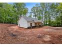 Exterior side view of single story home on large dirt lot and surrounded by trees at 1765 Harmony Rd, Temple, GA 30179