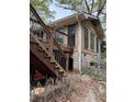 Home exterior with wooden stairs leading to a small deck, set upon a stone foundation in need of repair at 4216 Connor Dr, Ellenwood, GA 30294