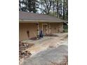 Side view of a detached garage with multiple doors, showing peeling paint and general disrepair at 4216 Connor Dr, Ellenwood, GA 30294