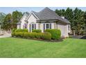 View of the yard and side of the house, showing meticulous lawn maintenance and mature bushes at 169 Twickenham Trce, Suwanee, GA 30024