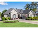 Charming home with a well manicured lawn, mature bushes, neutral colors, and attached garage at 169 Twickenham Trce, Suwanee, GA 30024