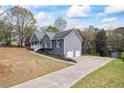 View of the home's exterior with a long driveway and a two-car garage at 65 Indian Springs Ne Dr, Rydal, GA 30171