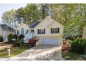 Charming home with a well-manicured front yard and a two-car garage nestled among mature trees at 3027 Clove Tree Ln, Woodstock, GA 30189