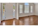 Light-filled foyer with gleaming hardwood floors and views of the front yard through large windows at 3027 Clove Tree Ln, Woodstock, GA 30189