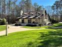 Charming home featuring three dormers, brick exterior, covered porch, manicured lawn, and an inviting front entrance at 1049 Panola Rd, Ellenwood, GA 30294