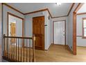 Bright foyer with wooden door, staircase, and light hardwood floors creating a warm entrance at 2003 Graystone Pkwy, Grayson, GA 30017
