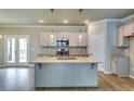 Modern kitchen featuring a large center island, stainless steel appliances, and stylish pendant lighting at 3855 Shelleydale Dr, Powder Springs, GA 30127