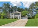 Traditional two-story home featuring a paved driveway, mature trees, and well-maintained lawn at 4147 Pinehurst Valley Dr, Decatur, GA 30034