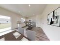 A spacious kitchen with stainless steel appliances and white cabinetry, connected to an open-plan dining area at 7763 Sudbury Cir, Covington, GA 30014