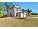 A two-story brick home featuring a two-car garage, well-maintained lawn, and landscaping at 2021 Adam Acres Dr, Lawrenceville, GA 30043