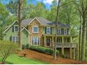 Charming two-story home with stone and green siding and a welcoming covered front porch at 104 Kremer Falls Trce, Canton, GA 30114