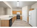 Bright kitchen featuring wood cabinets, stainless steel appliances, and laminate flooring at 2991 Greyhawk Ln, Cumming, GA 30040