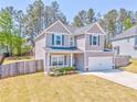 A charming two-story home with a manicured lawn and an attached two-car garage at 1302 Gardenia Ct, Villa Rica, GA 30180