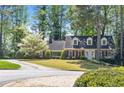 Charming two-story brick home with blue shutters and a lush front yard featuring a beautiful blossoming tree at 1000 N Harbor Ct, Atlanta, GA 30328