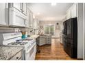 Spacious kitchen with white cabinets, granite countertops, stainless steel appliances, and hardwood floors at 105 Blackberry Ct, Woodstock, GA 30188