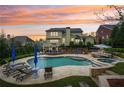 Luxury backyard featuring a sparkling pool, jacuzzi, and outdoor seating under a colorful sunset at 1401 Kings Park Nw Dr, Kennesaw, GA 30152