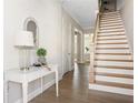Inviting entryway with hardwood floors, a white console table, and a staircase leading to the upper level of the home at 4356 Jenkins Ne Dr, Roswell, GA 30075