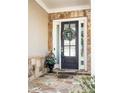 Elegant front entrance featuring a wreath on the door, stone accents, and decorative plants, creating a welcoming appeal at 4356 Jenkins Ne Dr, Roswell, GA 30075