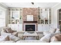 Cozy living room featuring a brick fireplace, built-in shelving, and comfortable seating, perfect for relaxation at 4356 Jenkins Ne Dr, Roswell, GA 30075