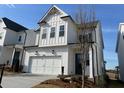 Beautiful two-story home featuring white siding, a two-car garage, and manicured landscaping at 631 Skytop Dr, Cumming, GA 30040