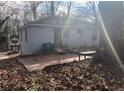 View of the back of the one-story house with brick patio, small yard and mature trees at 2168 Clanton Ter, Decatur, GA 30034