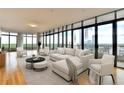 Bright living room featuring a large sectional sofa, modern seating, and floor-to-ceiling windows with city views at 750 Park Ne Ave # 13E, Atlanta, GA 30326