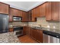 A kitchen showcasing wood cabinets, granite countertops, stainless steel appliances, and tiled backsplash at 11 Perimeter E Ctr # 1404, Atlanta, GA 30346