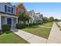 Street view of well-maintained townhomes with lush green lawns and concrete sidewalks at 1575 April Ln, Morrow, GA 30260
