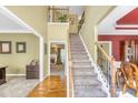 Spacious foyer featuring a carpeted staircase, hardwood floors, and views into other rooms at 1455 Oglethorpe Run Ln, Suwanee, GA 30024