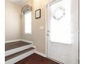 Light and airy entryway with wood floors, white trim, stairs and front door with sidelight at 3065 Windcrest Ct, Alpharetta, GA 30022